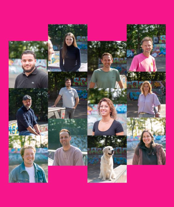 Verschillende volwassenen staan buiten voor met graffiti bedekte bouwwerken en bomen. Twee mannen zijn scherp op de voorgrond en anderen zijn vaag op de foto te zien. Het doet denken aan creatieve teams achter innovatieve websites of online diensten.